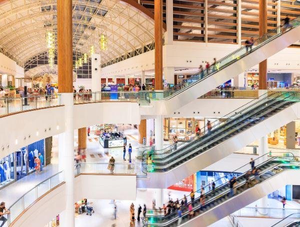 Interior de shopping com escadas rolantes, áreas de circulação e infraestrutura em vários pavimentos
